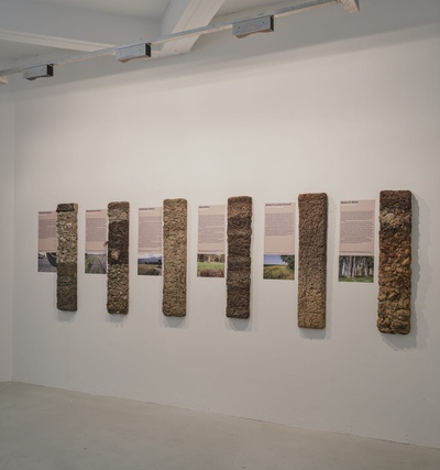 Blick in die Ausstellung "Boden für Alle. Eigennutz oder Gemeinwohl?"  mit sechs verschiedenen Bodenprofilen im aut