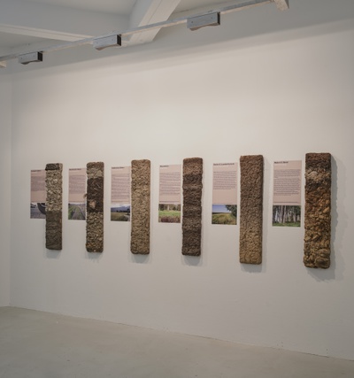Blick in die Ausstellung "Boden für Alle. Eigennutz oder Gemeinwohl?" mit sechs verschiedenen Bodenprofilen im aut