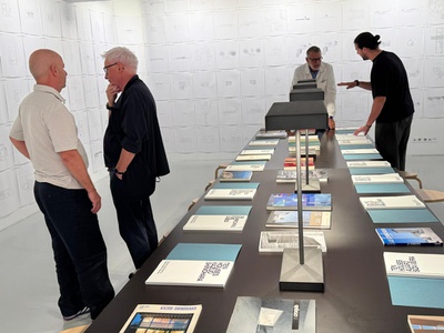 Walter Angonese und Tommaso Fantini zeigen Riccardo Blumer, Direktor der USI - Accademia di architettura, die Ausstellung – © aut